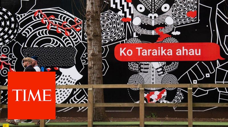 People walk past Maori language signs in Wellington on September 13, 2018