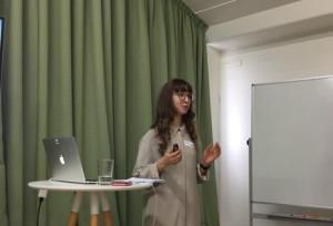 Alex Garkavenko, Data architect at Dexibit standing in front of a green curtain wearing a beige top