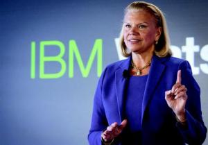 Ginni Rometty - CEO, IBM standing in front of a blue wall with the word IBM on it