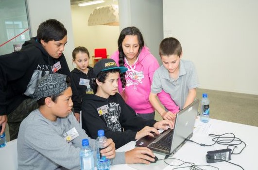 A bunch of kids around a computer