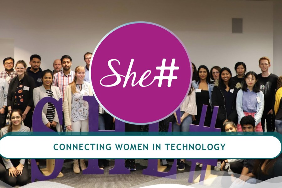 Group of women at a She# event with the logo in the middle