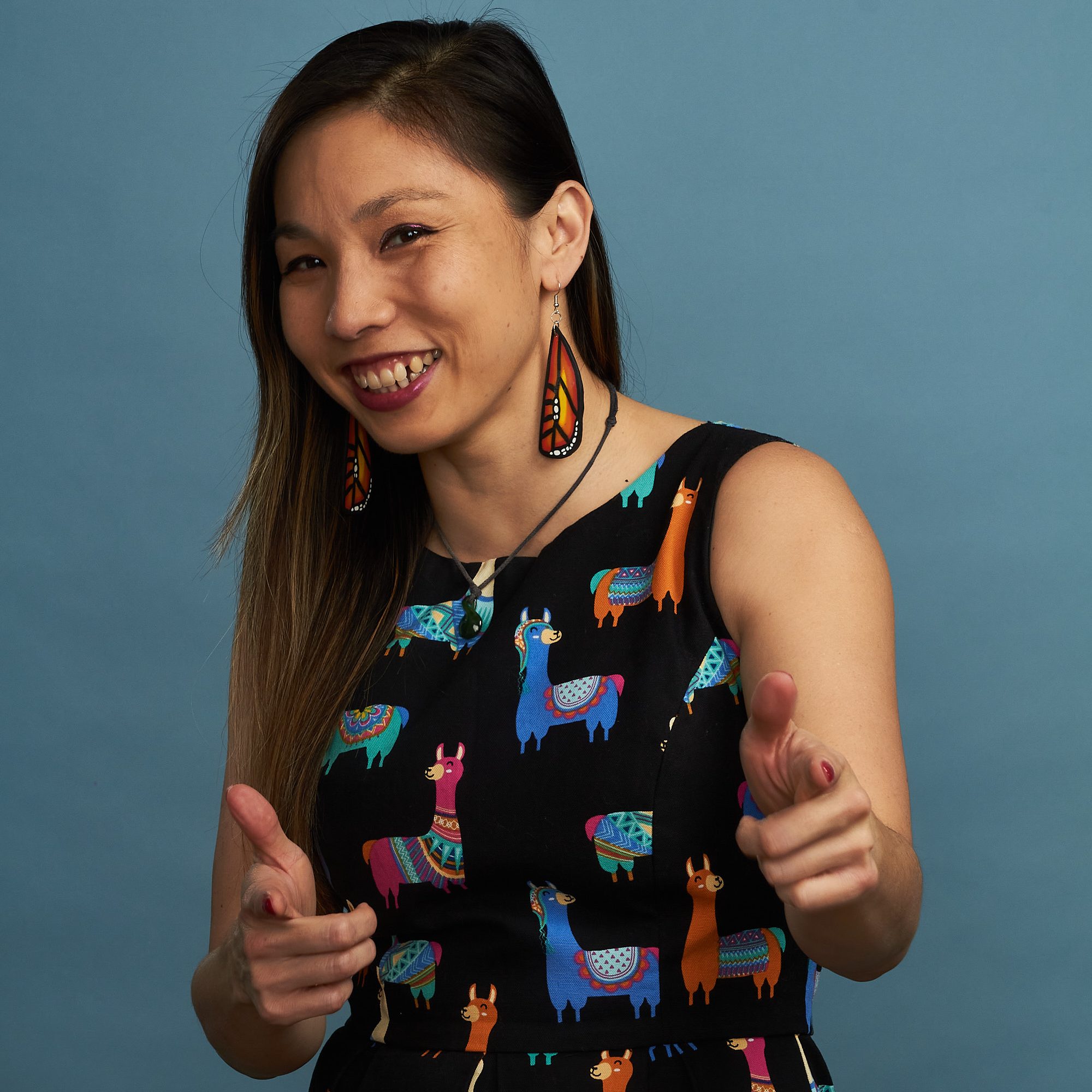 Photo of Vivian Chandra in a llama dress doing pistol fingers