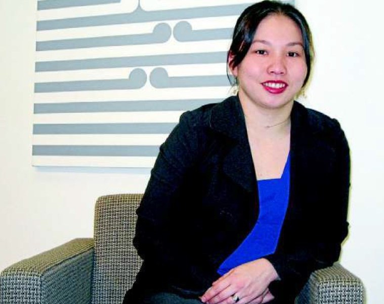 Me in fropnt of some Koru art wearing a black blazer over a blue top