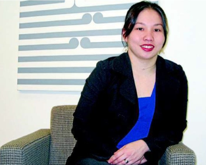 Me in fropnt of some Koru art wearing a black blazer over a blue top