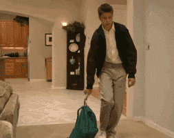 gif of a man dropping a green backpack and collapsing face down on a floor
