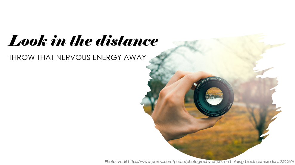 Largely decorative image of a hand holding a camera lens so that you can see the distance in sharp relief. The words say "Look in the distance. Throw that nervous energy away"
