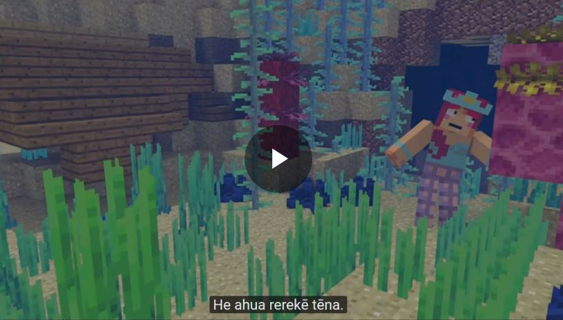 Screenshot from the minecraft tutorial it shows a woman amongst some grass and the caption says He ahua rerekē tēna