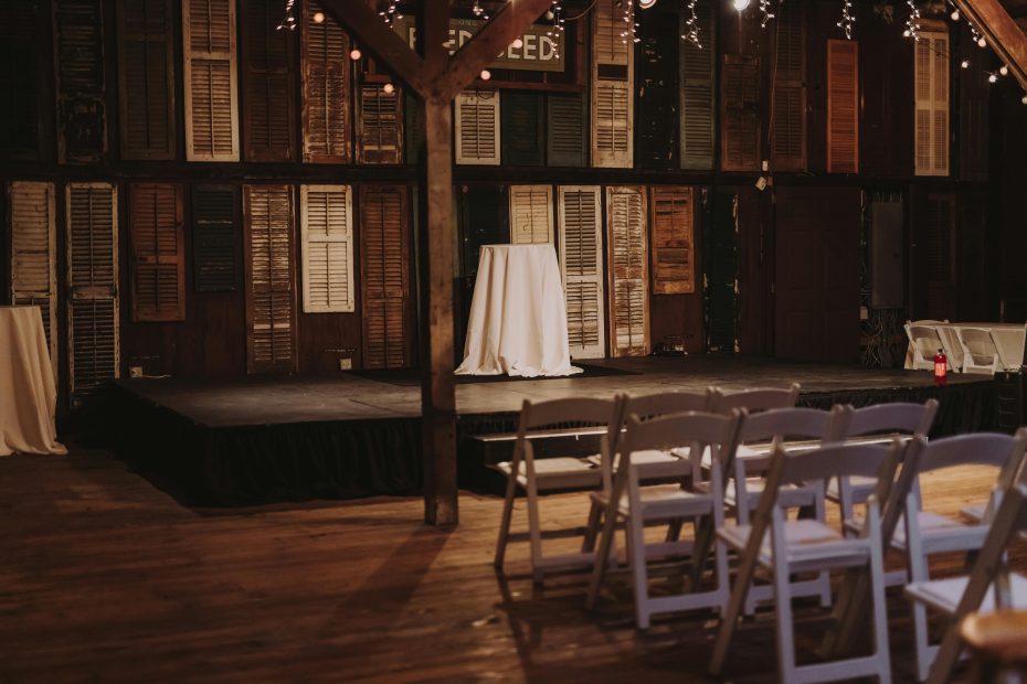Largely decorative image of a rustic stage, you can see the wooden seats and an empty stage